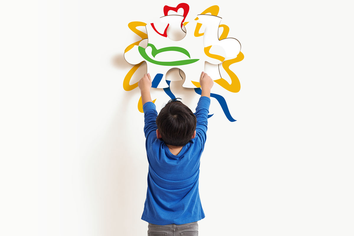 Kind vervollständigt wellcome-Logo in Puzzleform