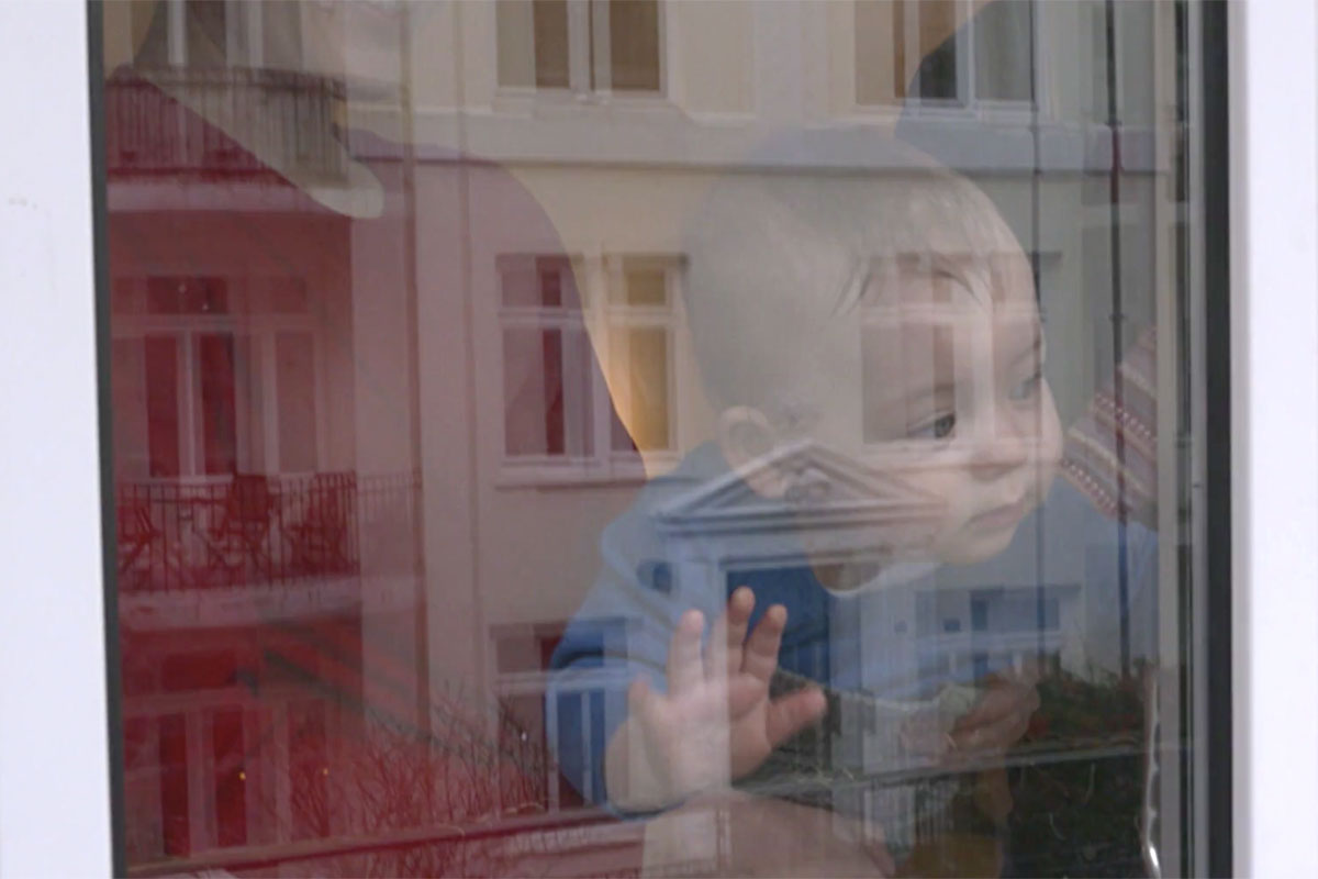 Kleinkind schaut aus dem Fenster